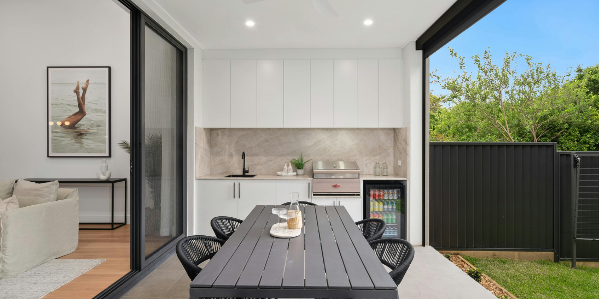 Covered patio with seamless indoor-outdoor transition, featuring natural wood finishes and modern outdoor seating — a top 2025 home renovation trend.